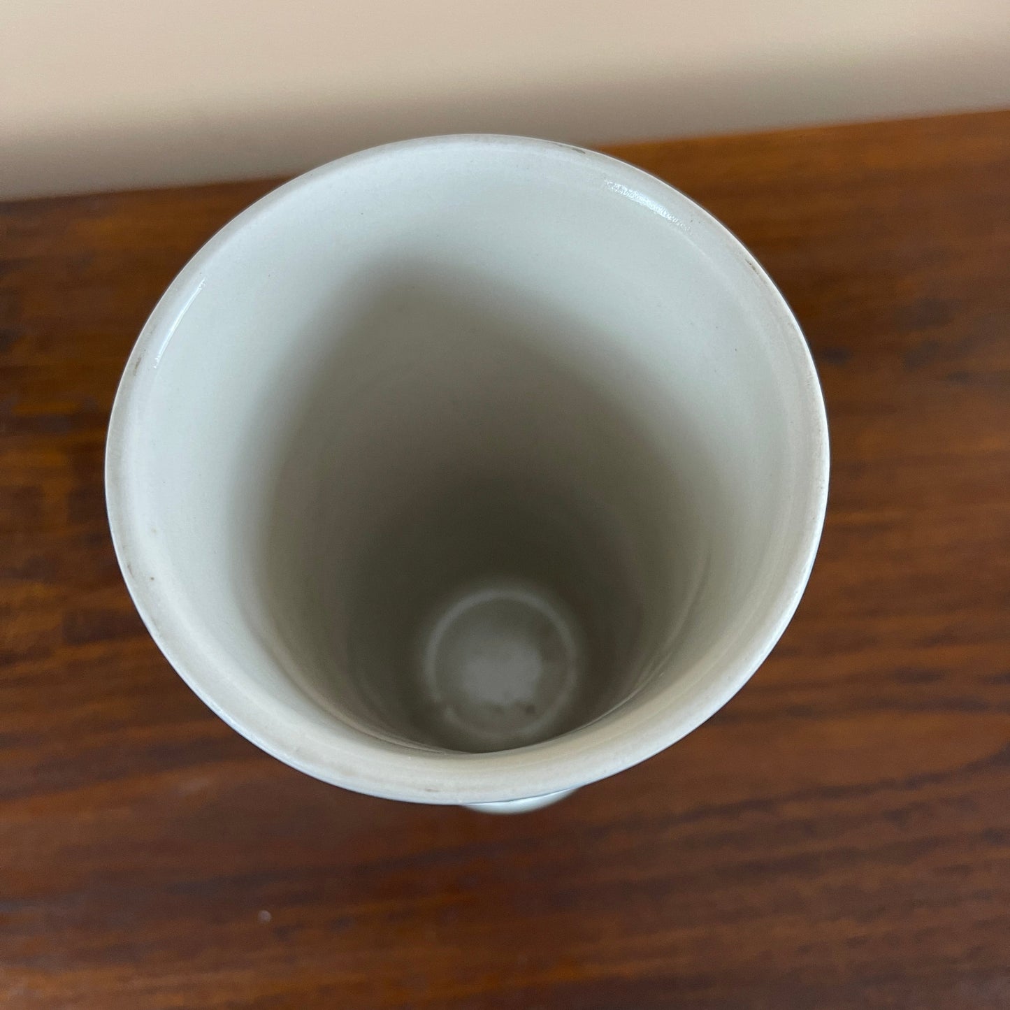 White ceramic cup on a wooden surface
