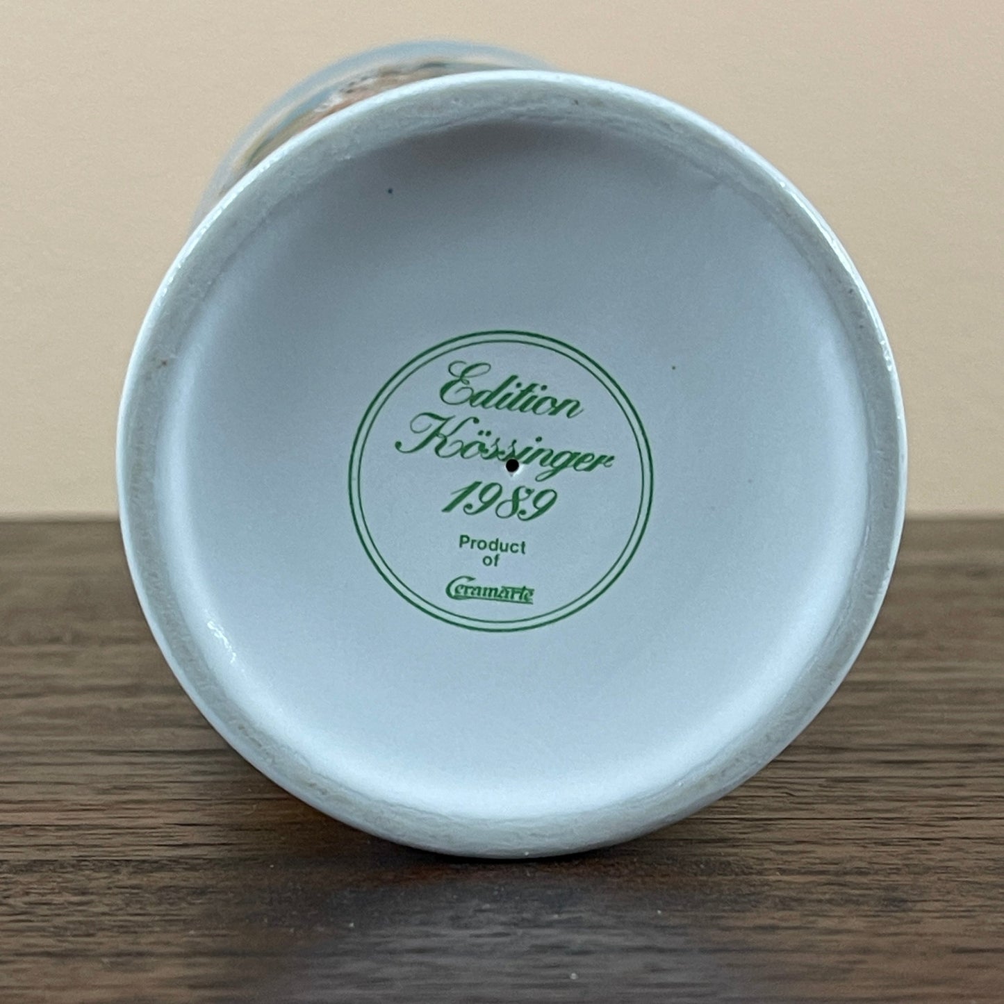 Ceramic vase with a green label on a wooden surface
