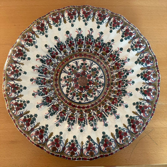 Decorative ceramic plate with intricate patterns on a wooden surface