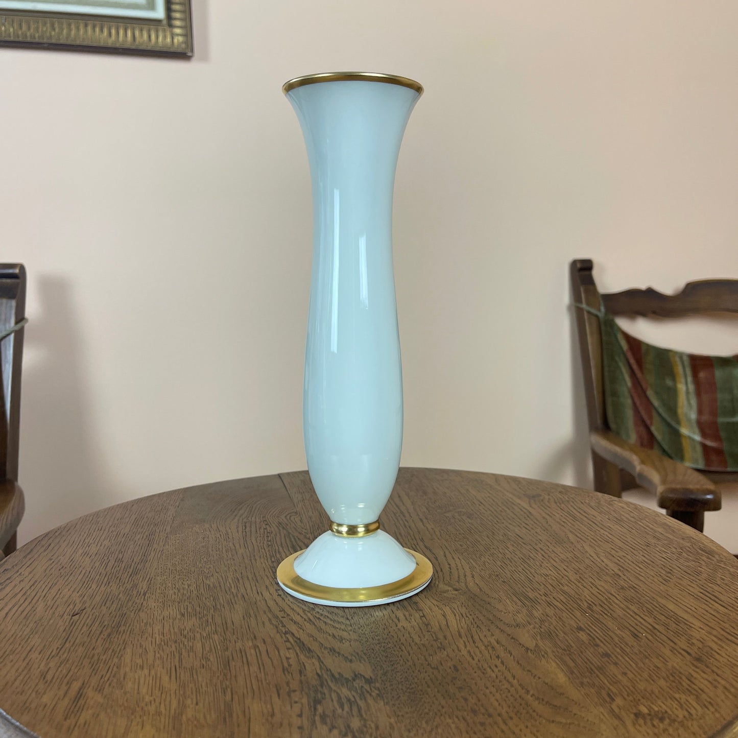 White vase with gold accents on a wooden table