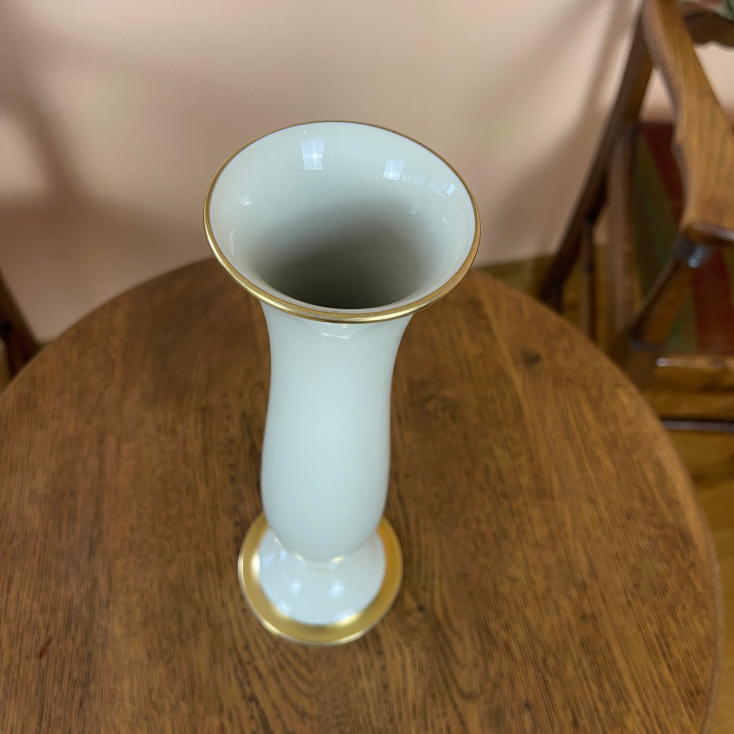 White vase with gold accents on a wooden table