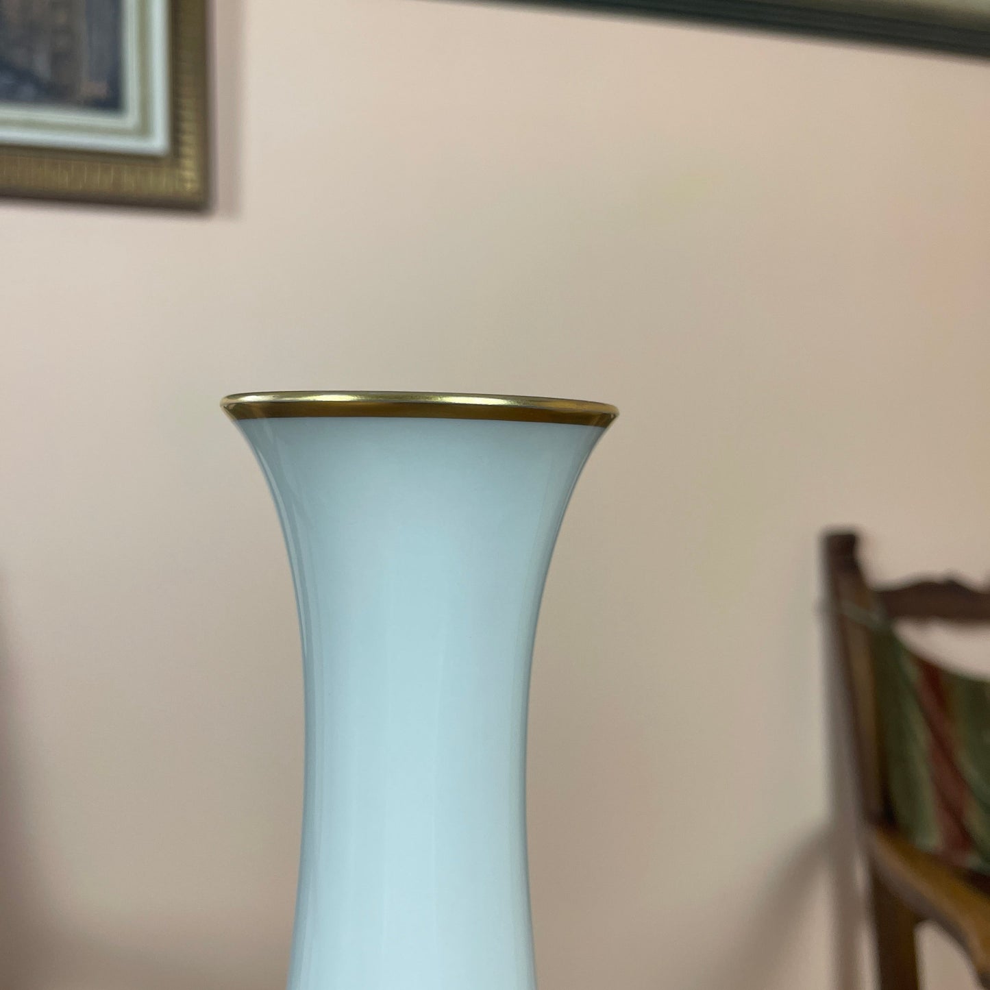 White vase with gold rim on a blurred background