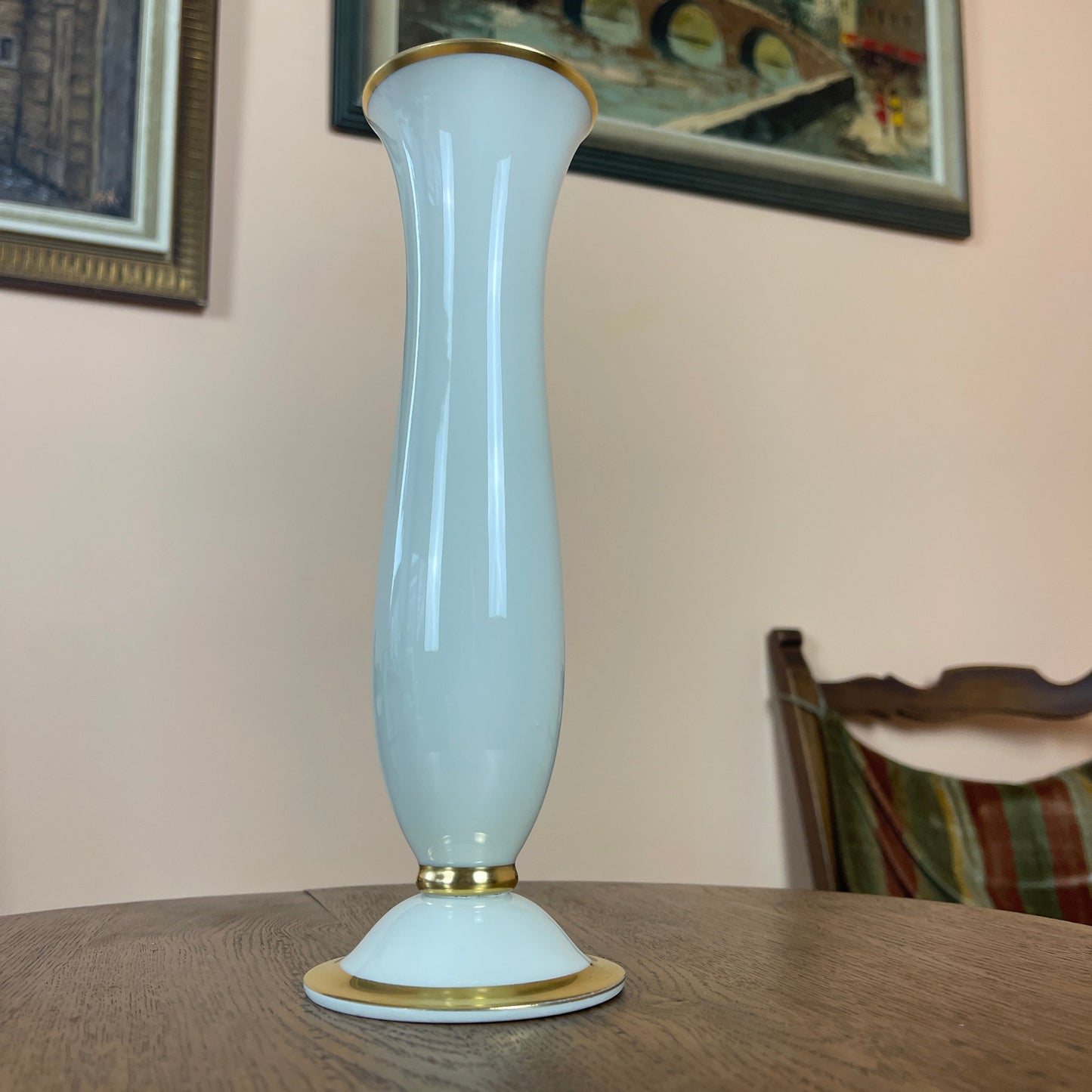 White vase with gold accents on a wooden table