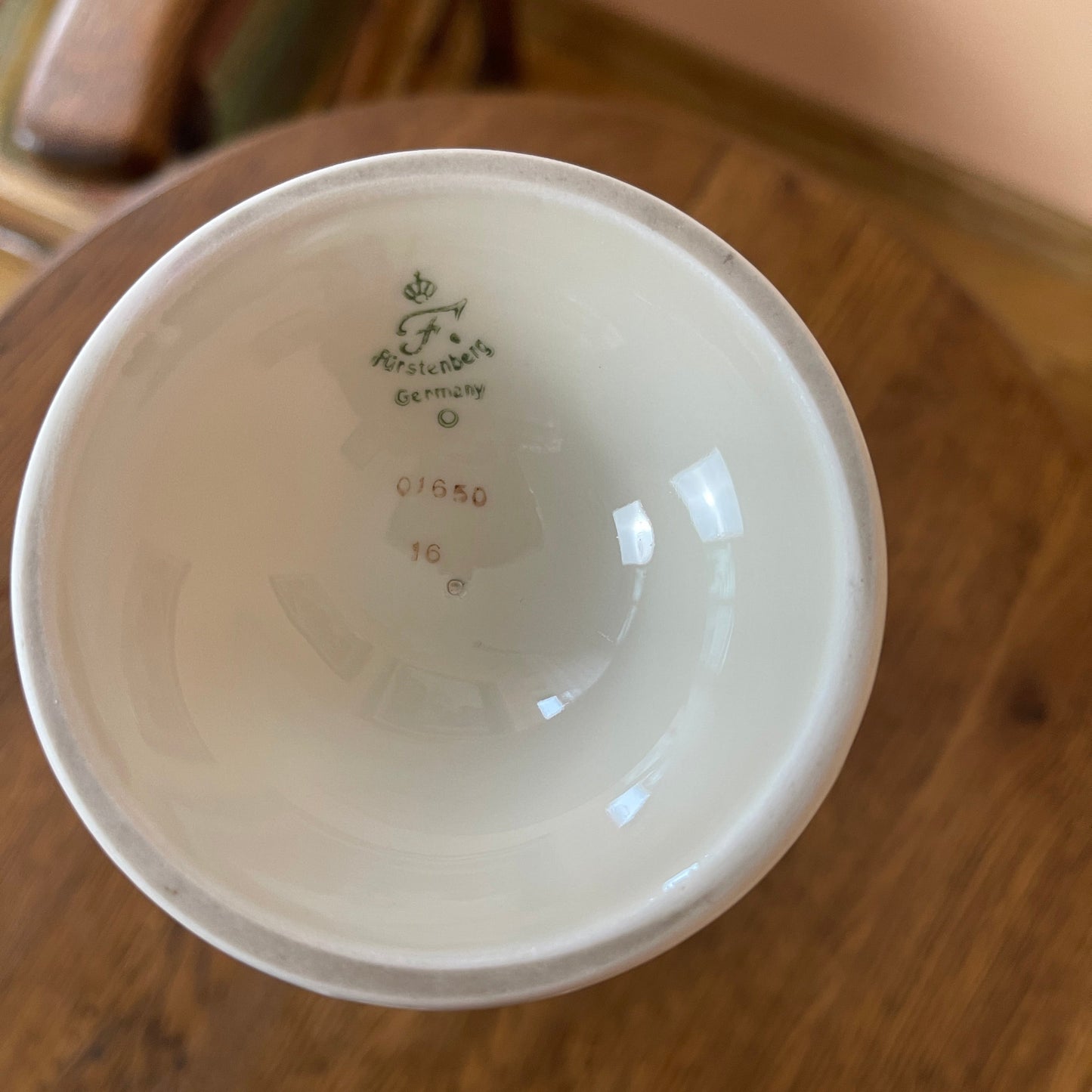 White ceramic bowl with branding on a wooden surface