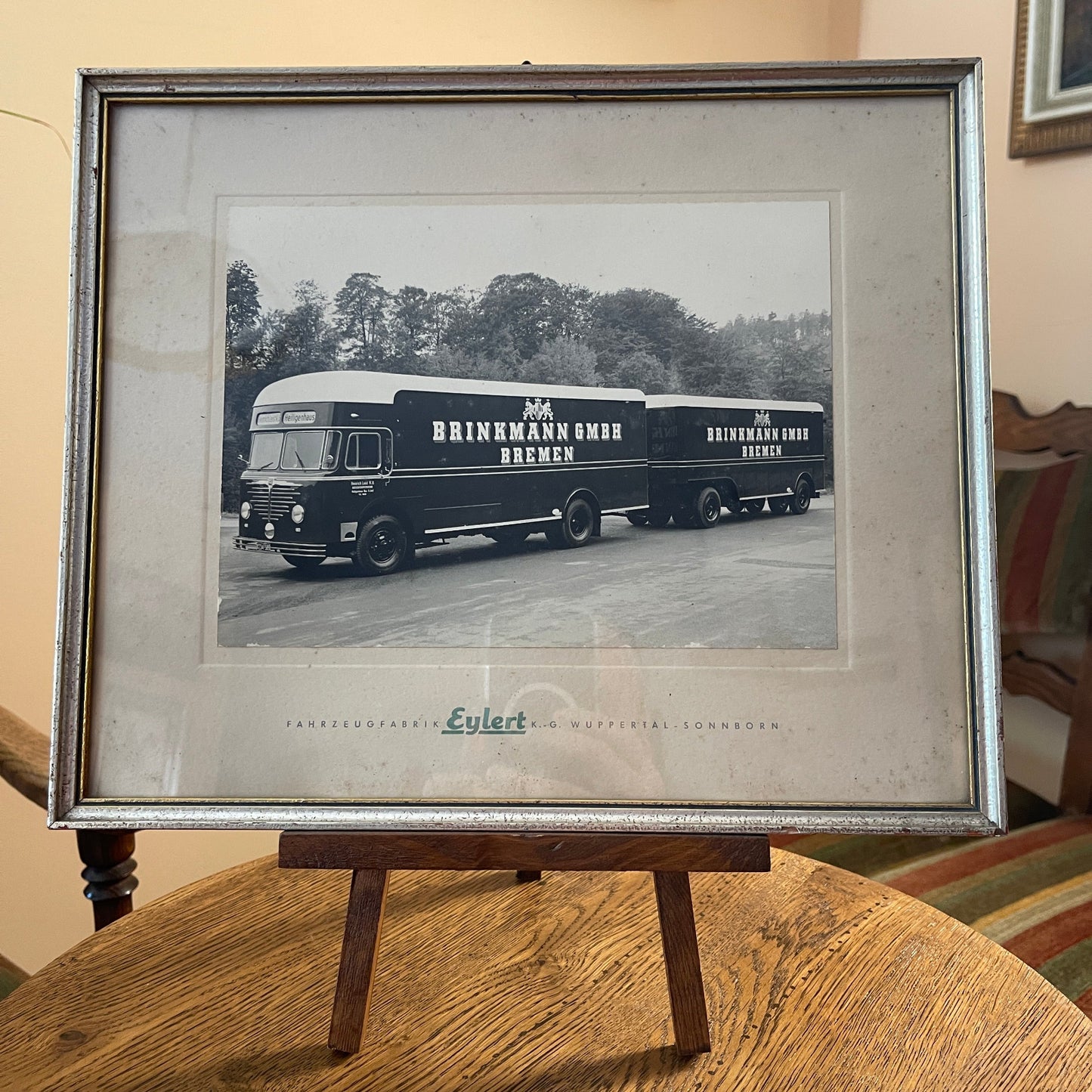 Framed black and white photograph of two Brinkmann buses on a wooden stand.