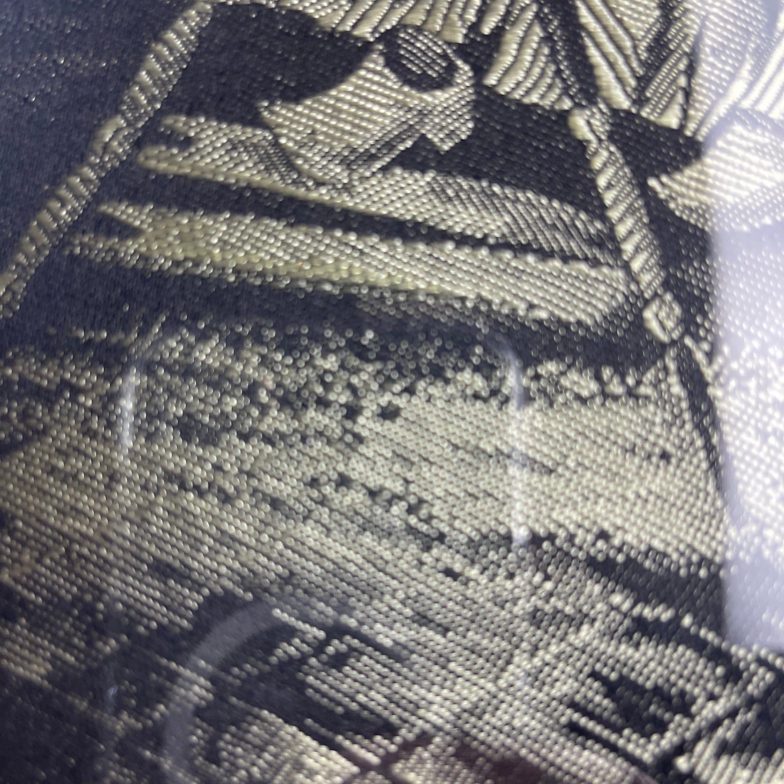 Close-up of a textured fabric with a pattern, possibly a tie or a piece of clothing.