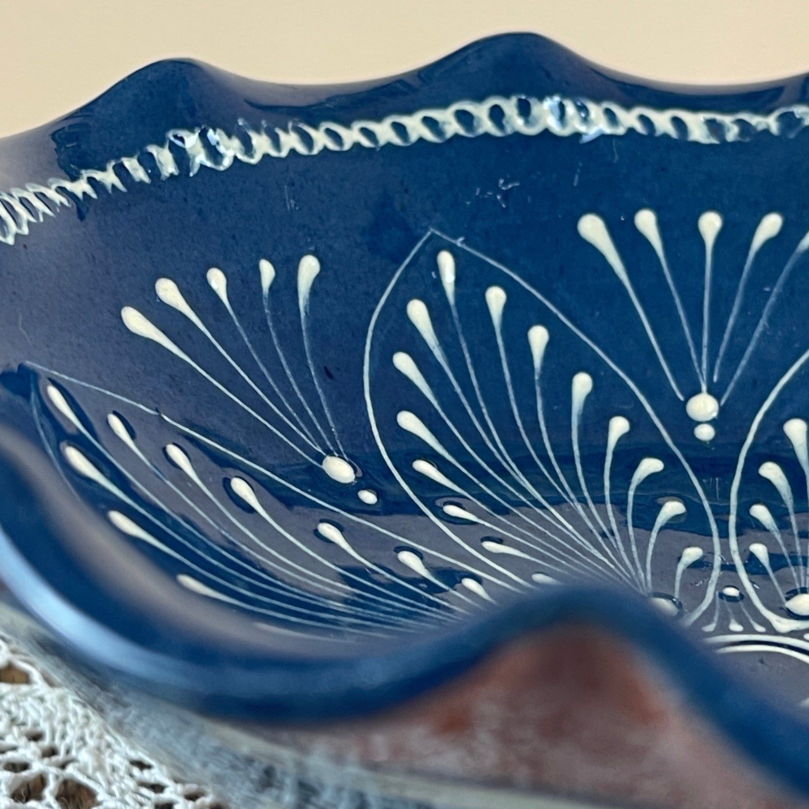 Blue ceramic dish with white floral patterns on a beige background