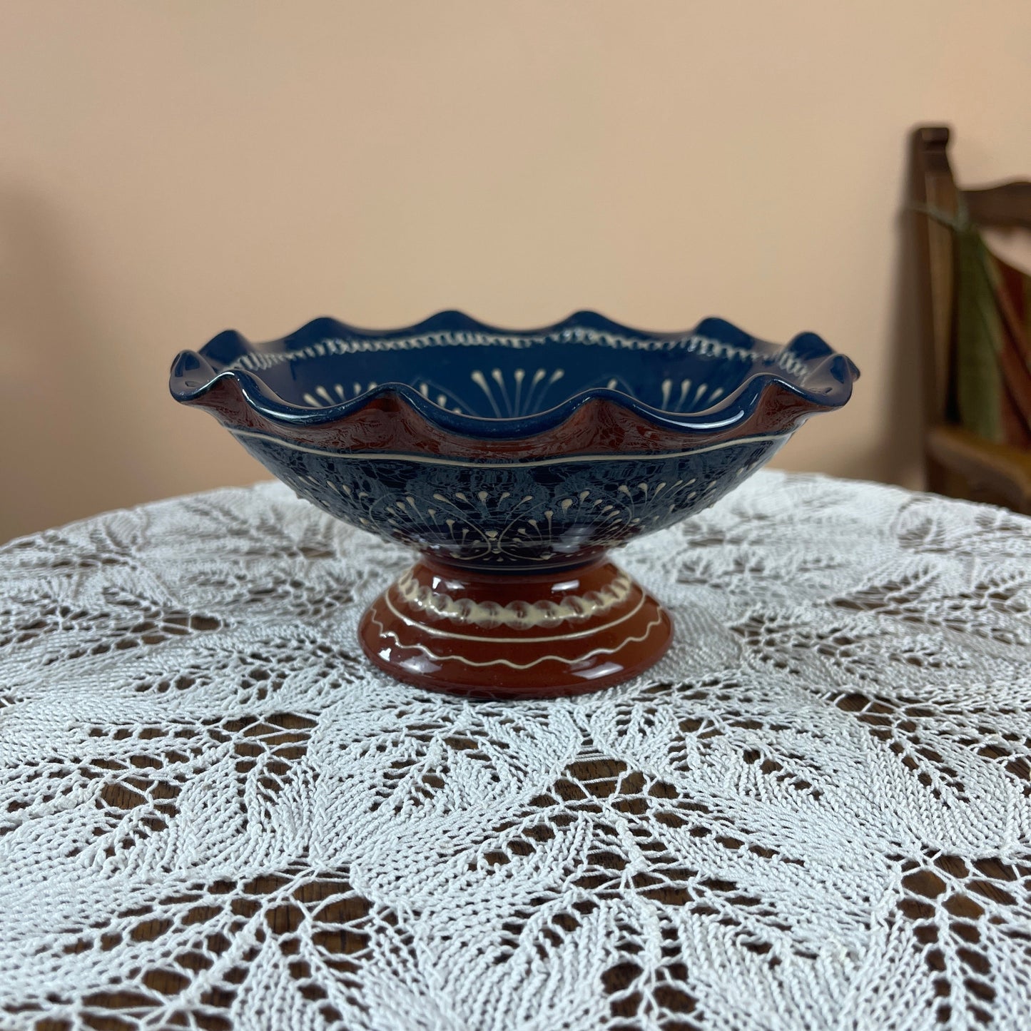 Decorative blue ceramic bowl on a lace tablecloth with a blurred background