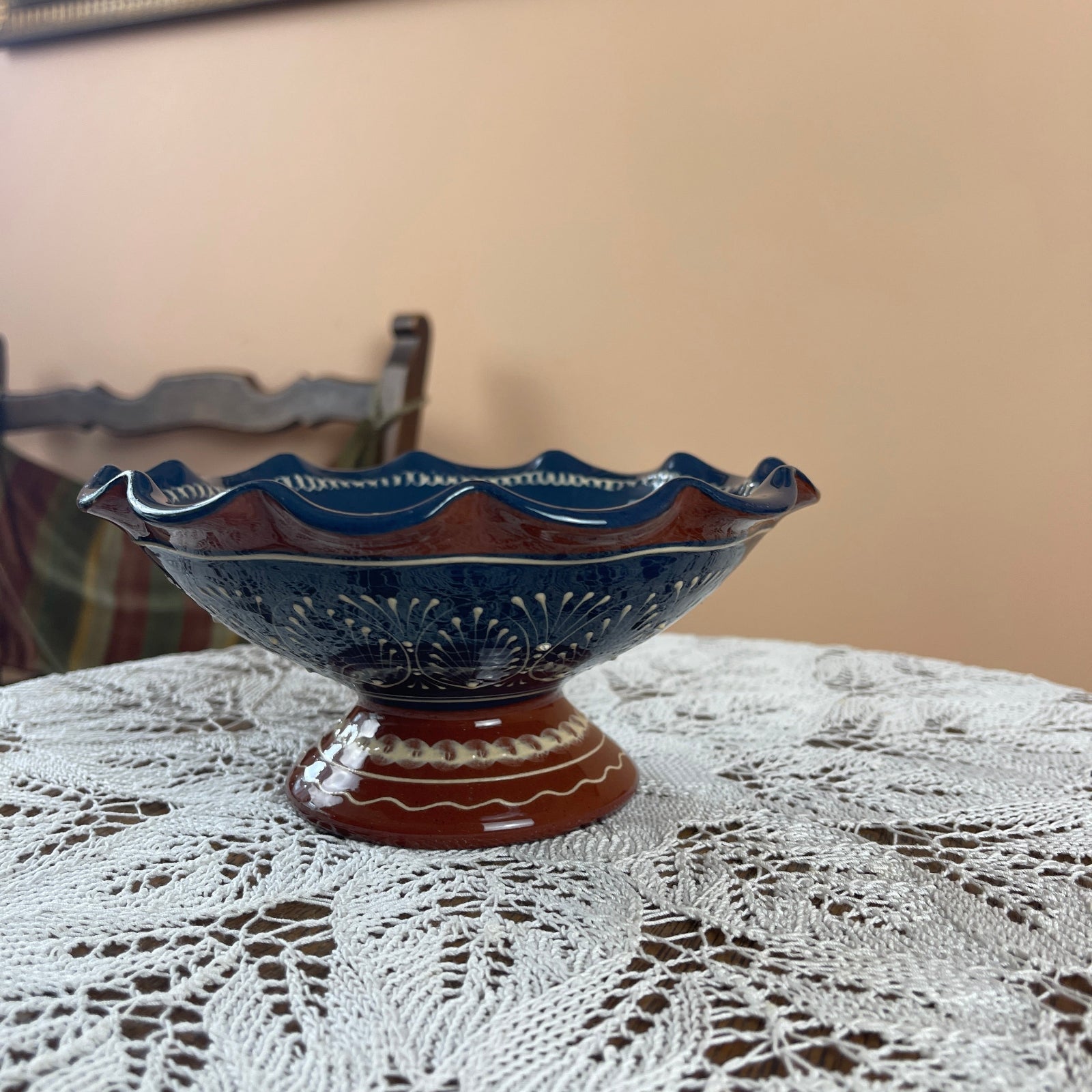 Decorative blue ceramic bowl on a lace tablecloth with a neutral background