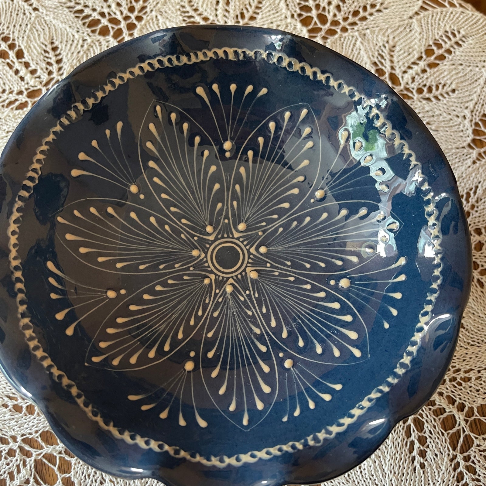Decorative blue plate with white floral pattern on a lace tablecloth