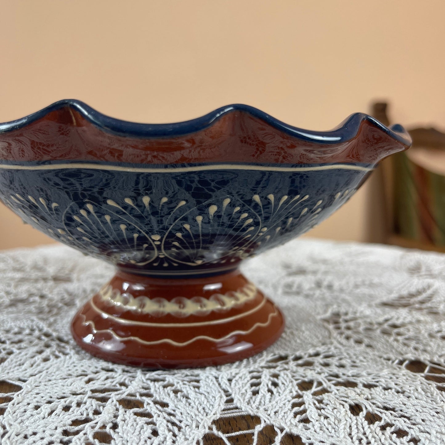 Decorative blue and brown ceramic bowl on a lace tablecloth