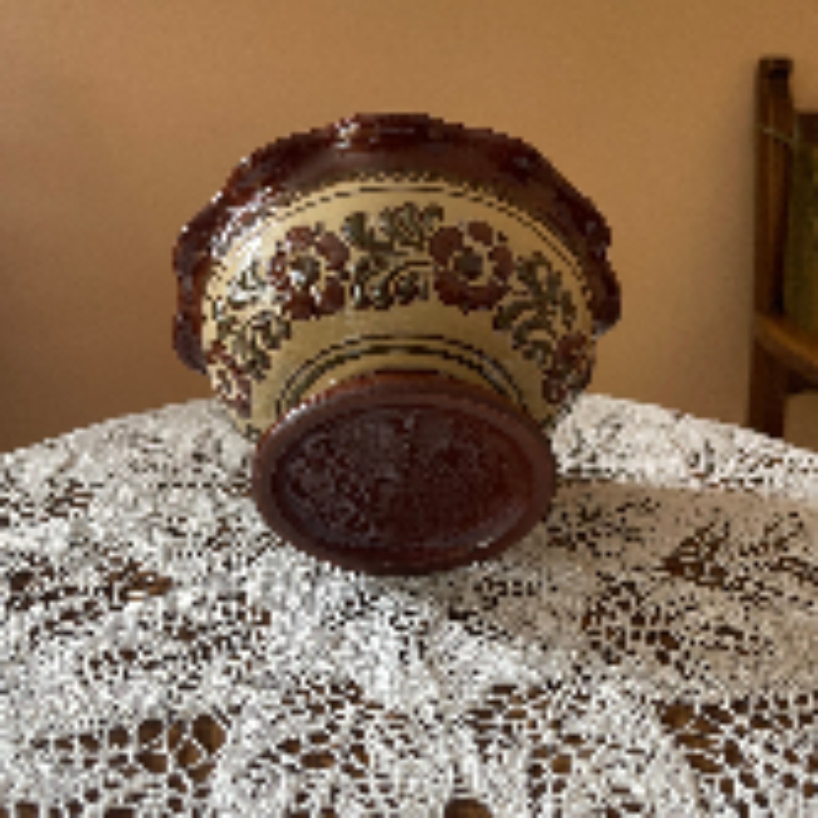 Decorative ceramic vase with floral patterns on a lace tablecloth