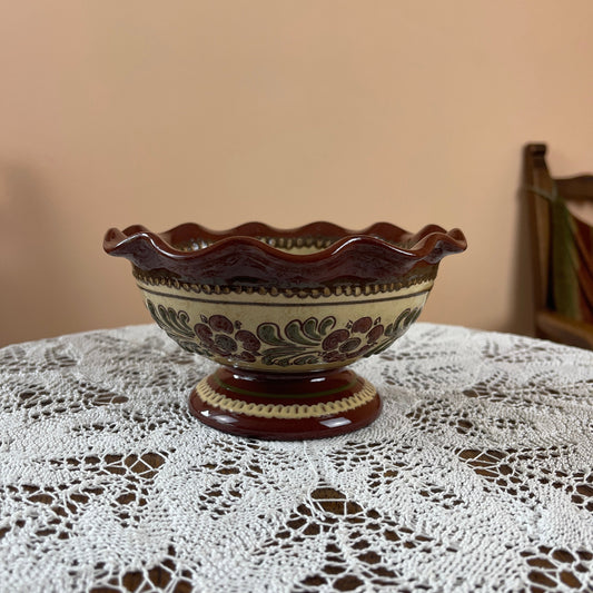 Decorative ceramic bowl with floral patterns on a lace tablecloth