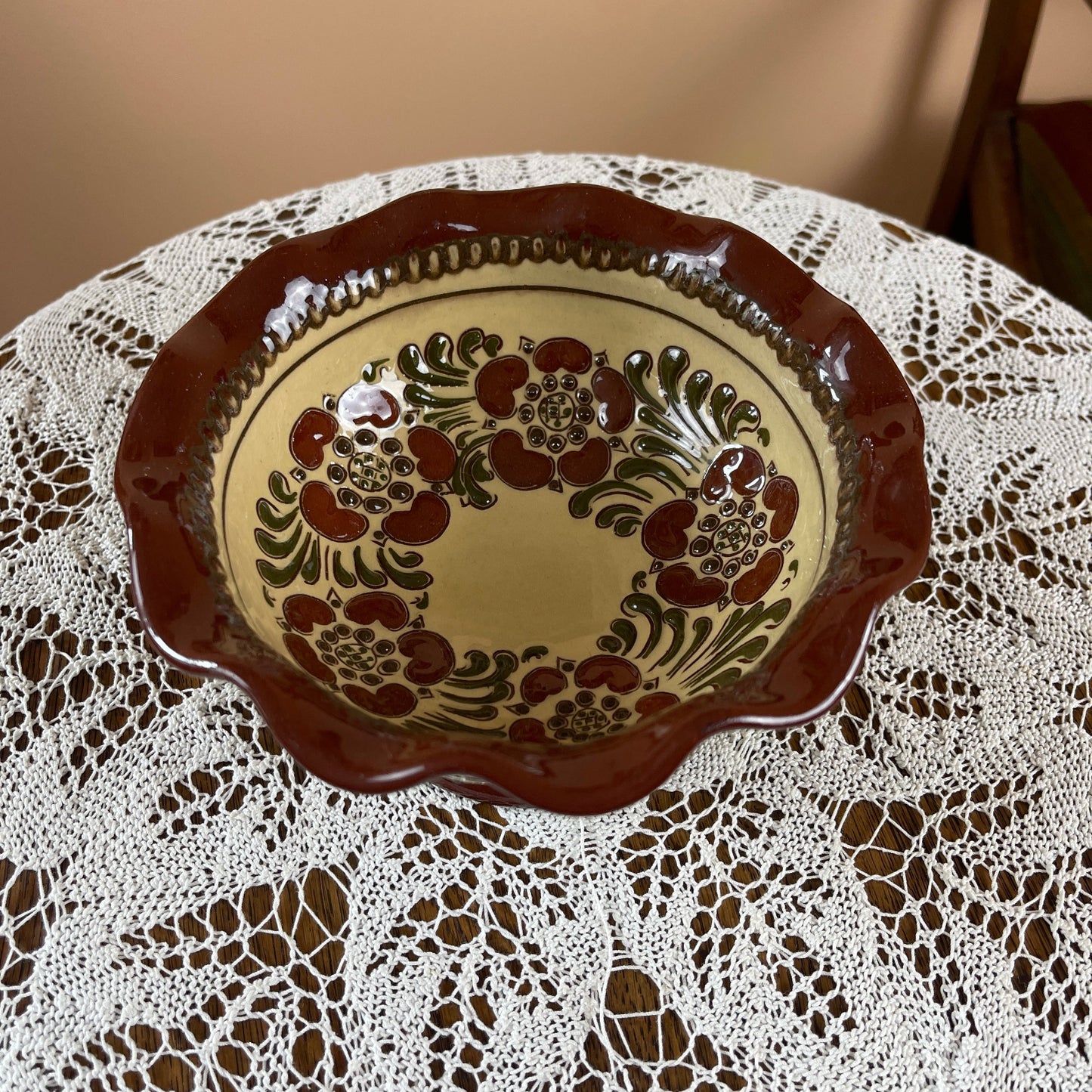 Decorative ceramic plate with floral pattern on a lace tablecloth