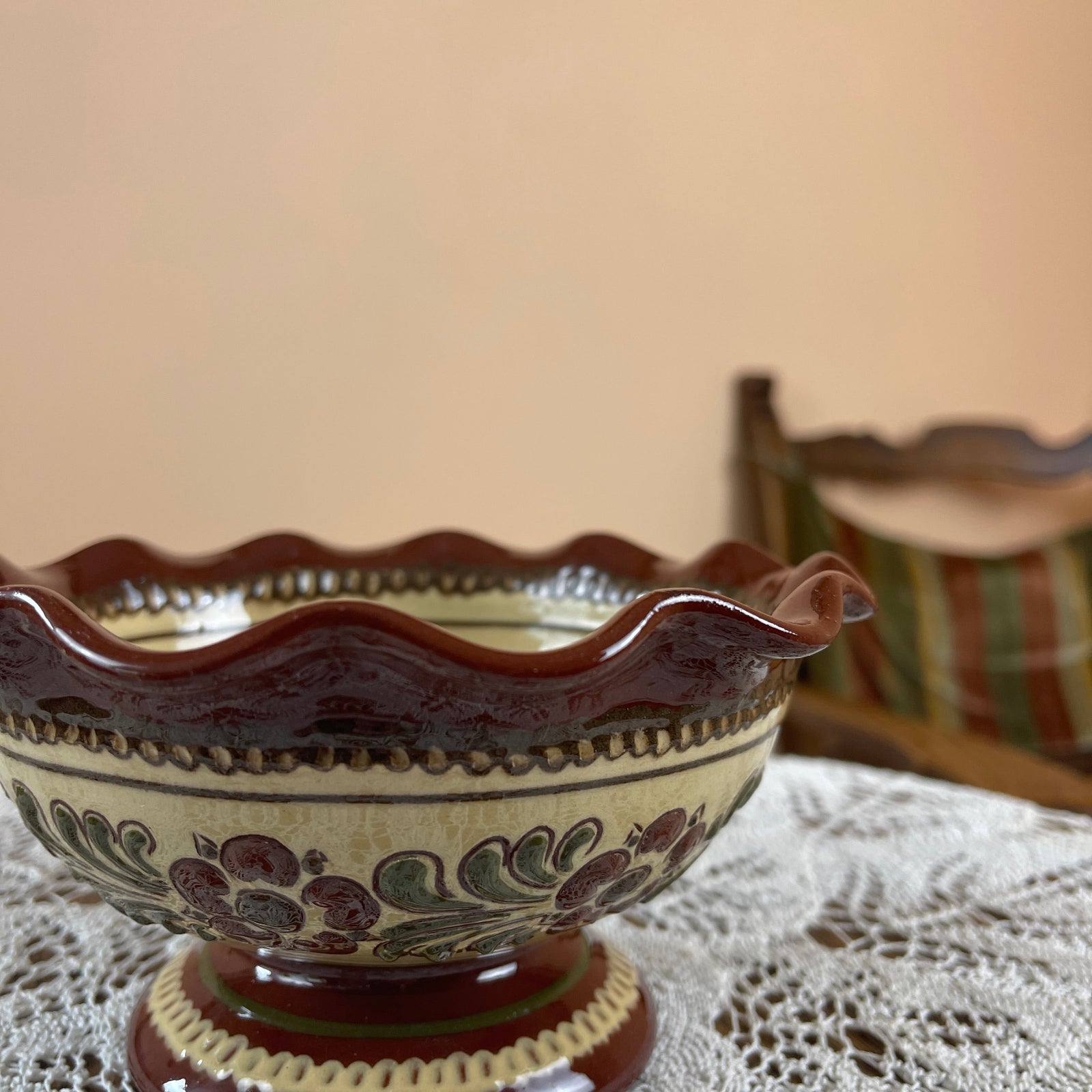 Decorative ceramic bowl with floral patterns on a lace tablecloth