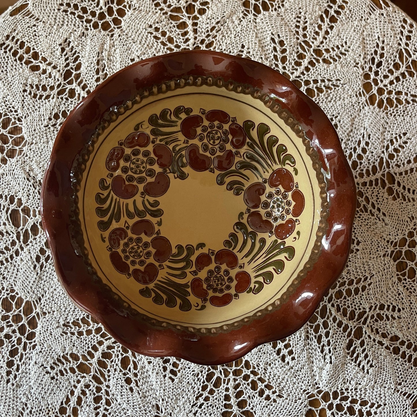 Decorative ceramic plate with floral patterns on a lace tablecloth