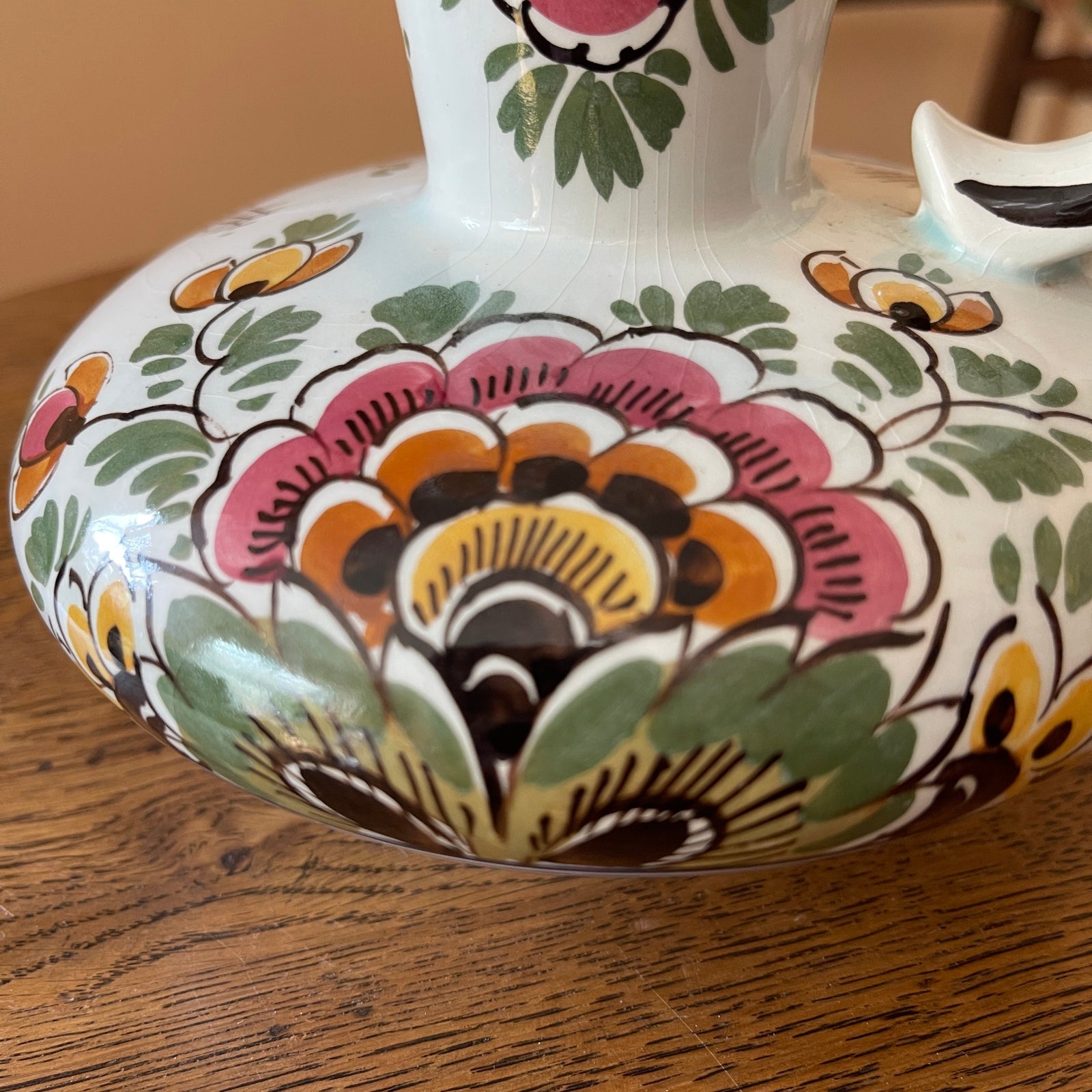 Decorative ceramic vase with floral patterns on a wooden surface