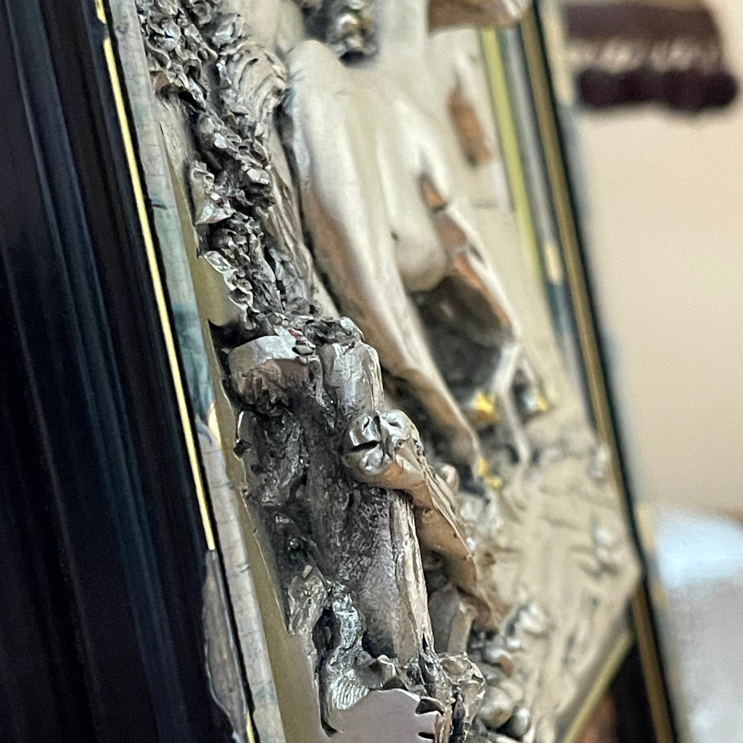 Close-up of a metallic object with intricate designs and reflective surface.