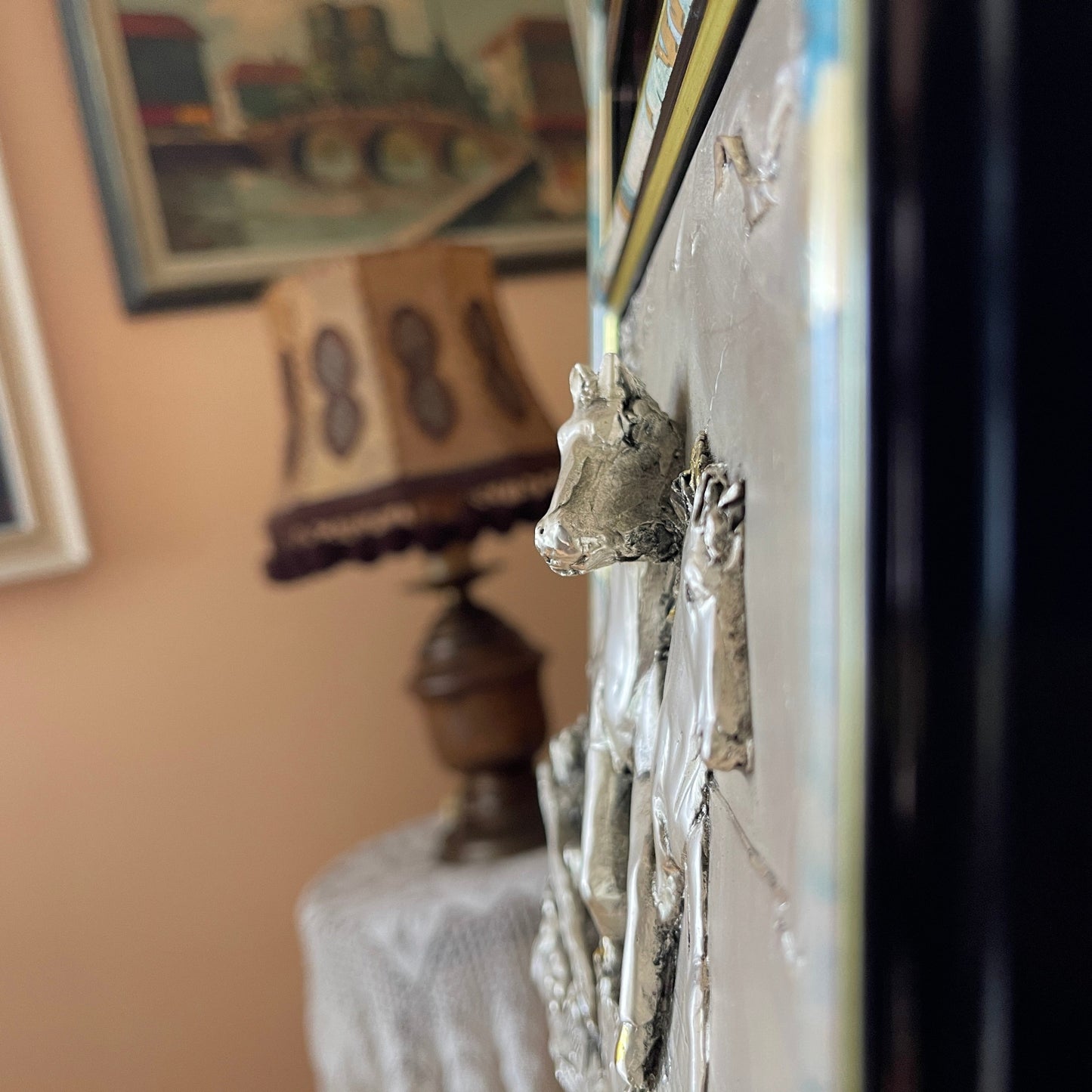 Decorative wall piece with a metallic animal head design in a room setting.