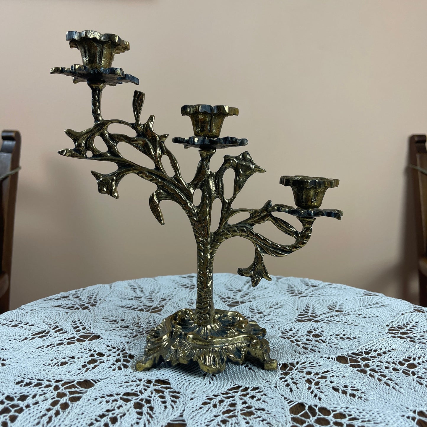 Decorative metal candelabra on a table with a lace tablecloth