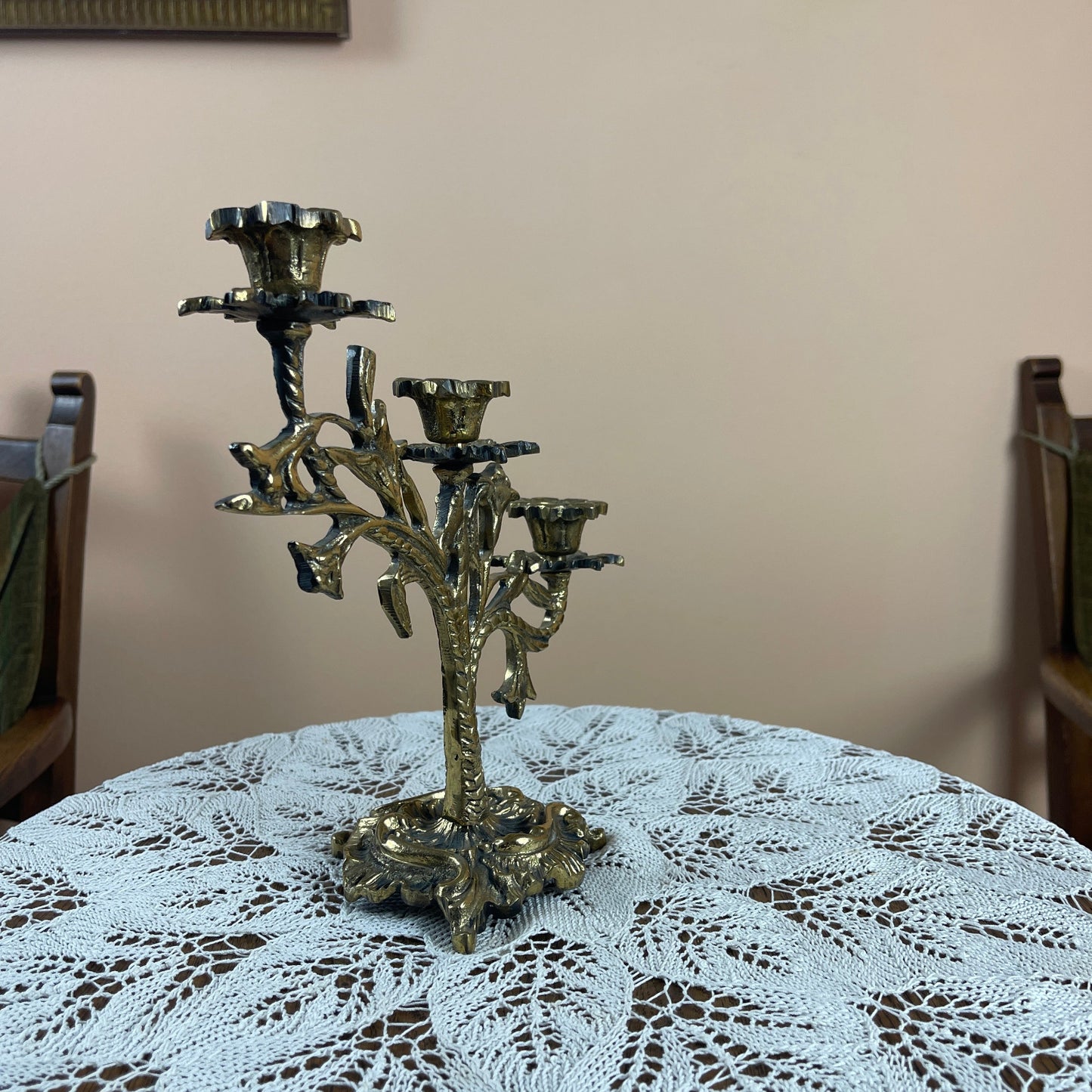 Decorative metal candelabra on a table with a lace tablecloth