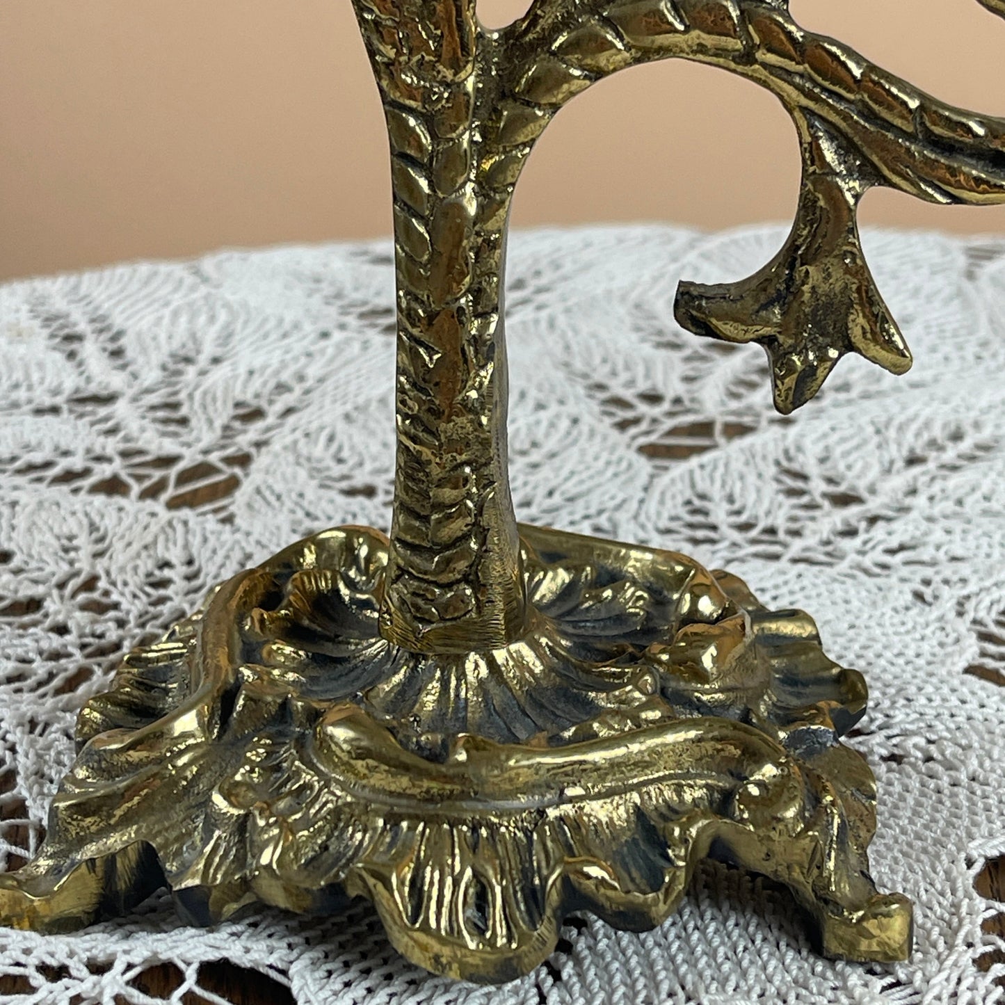 Decorative gold candle holder on a lace tablecloth