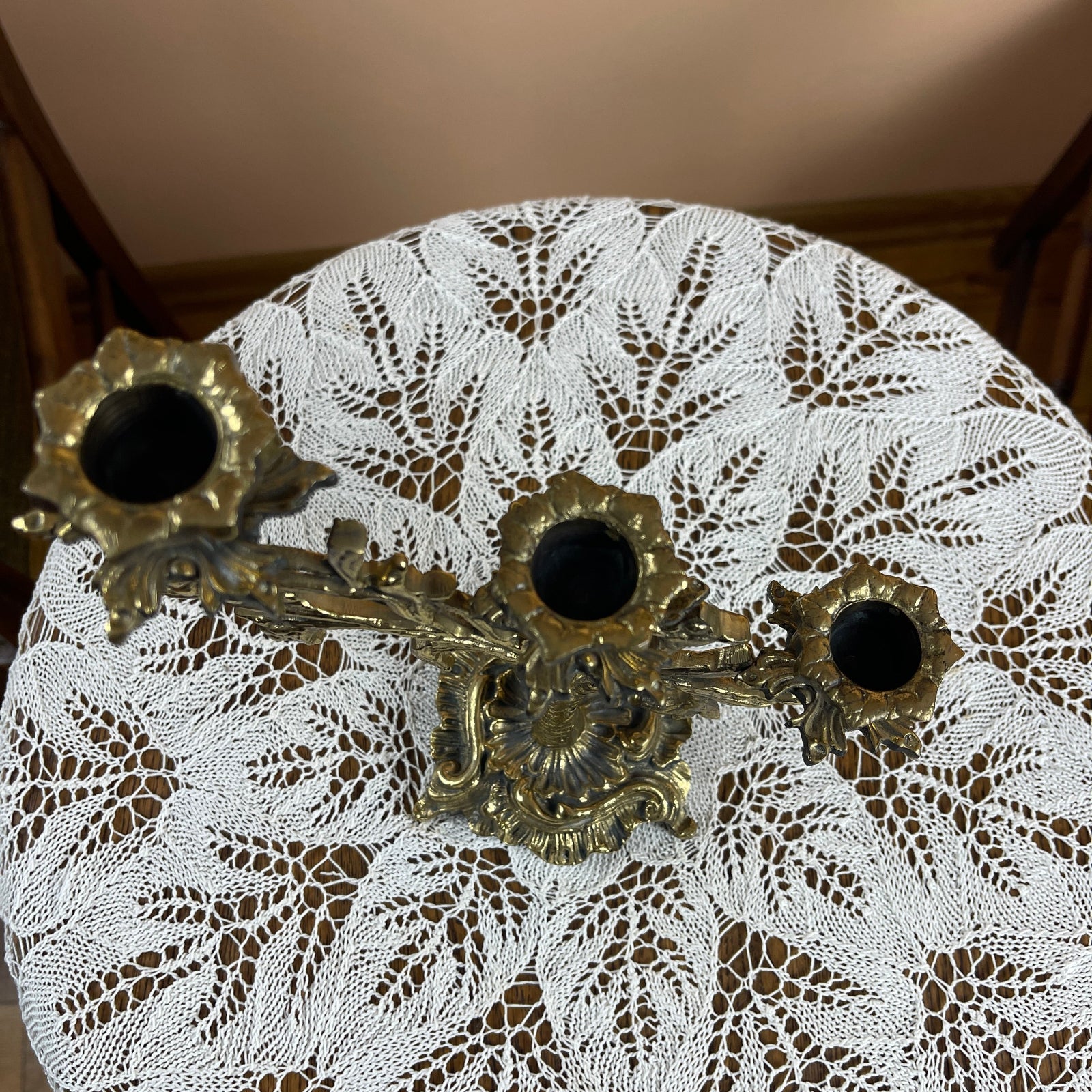 Decorative brass key-shaped object on a lace tablecloth