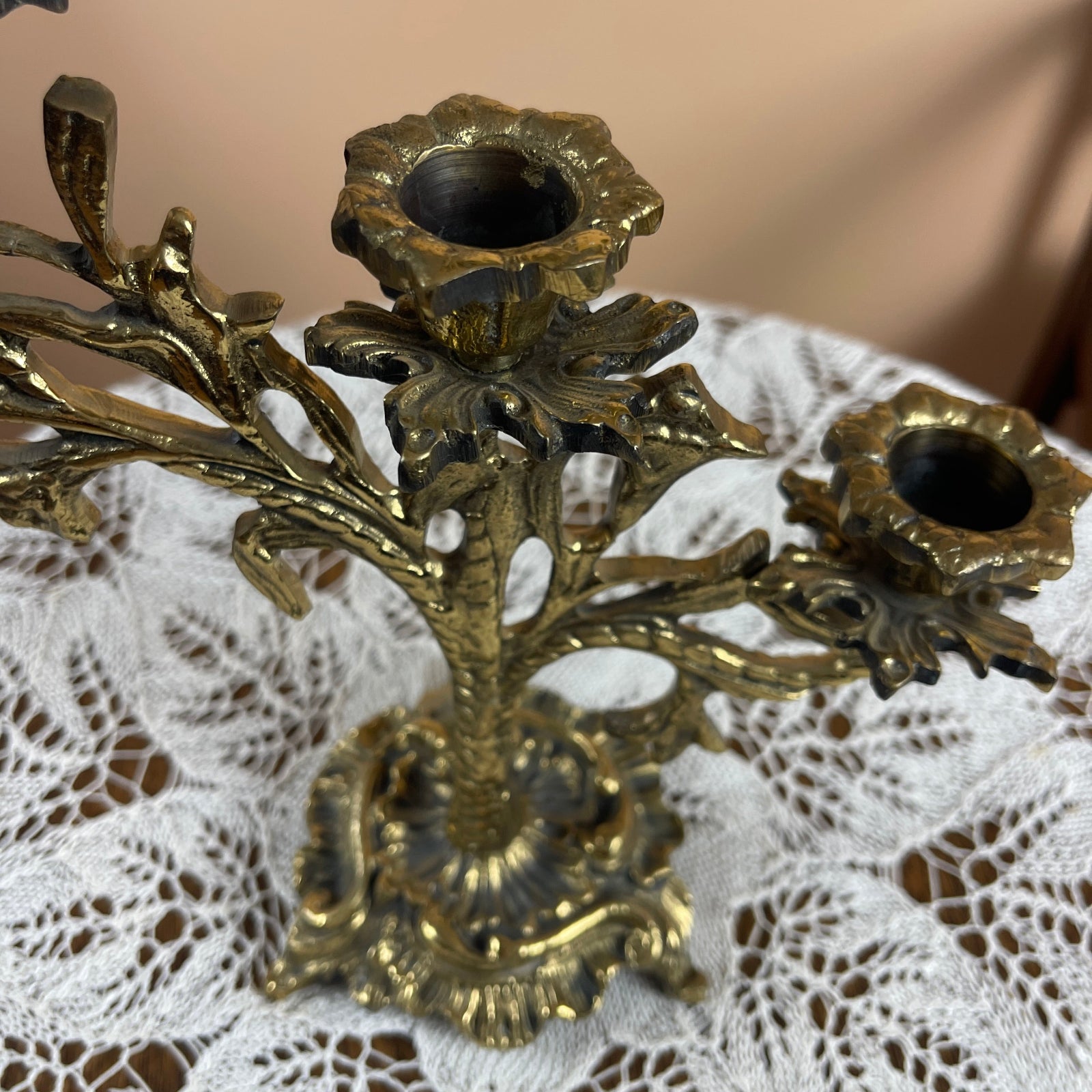 Decorative brass candle holder on a lace surface