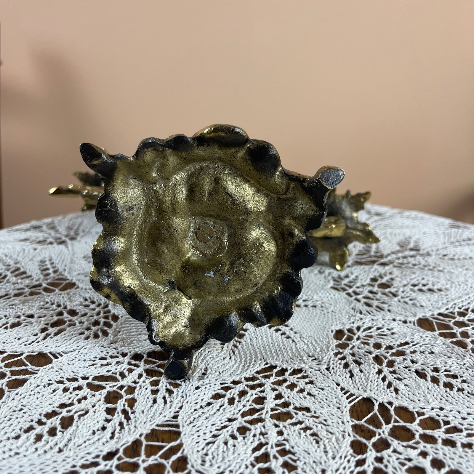 Decorative object with gold and black design on a lace tablecloth