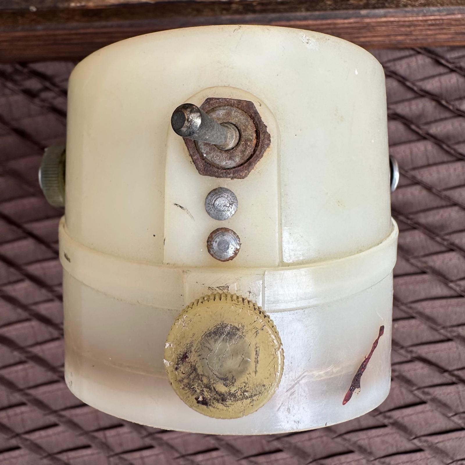Vintage mechanical component with gears and screws on a textured surface