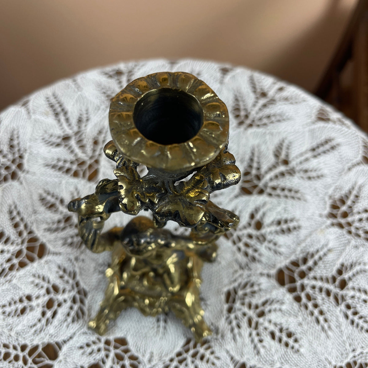 Decorative gold candle holder on a textured white surface