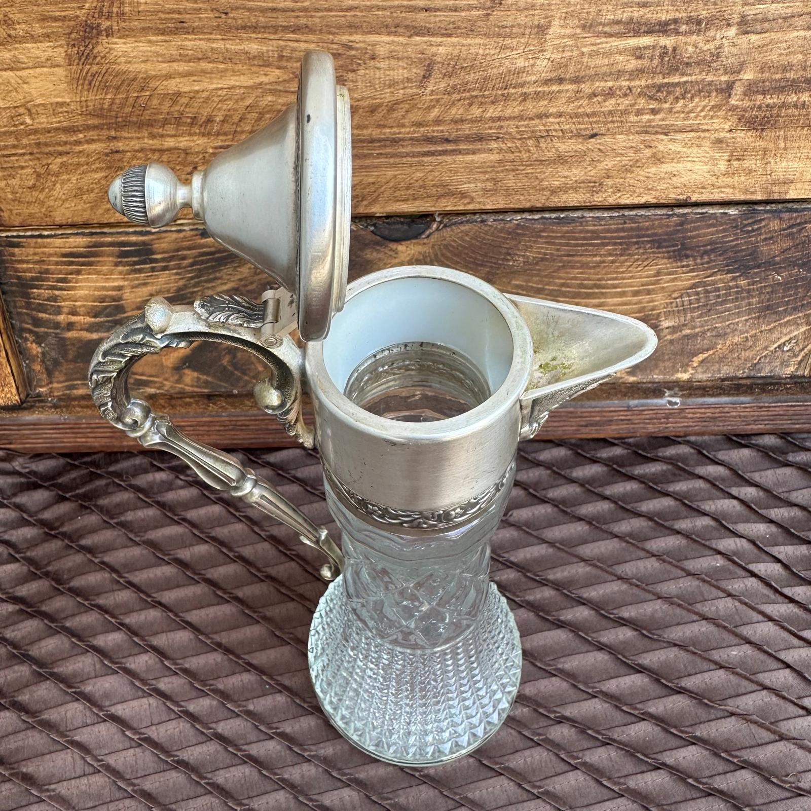 Decorative silver lamp with intricate design on a textured surface