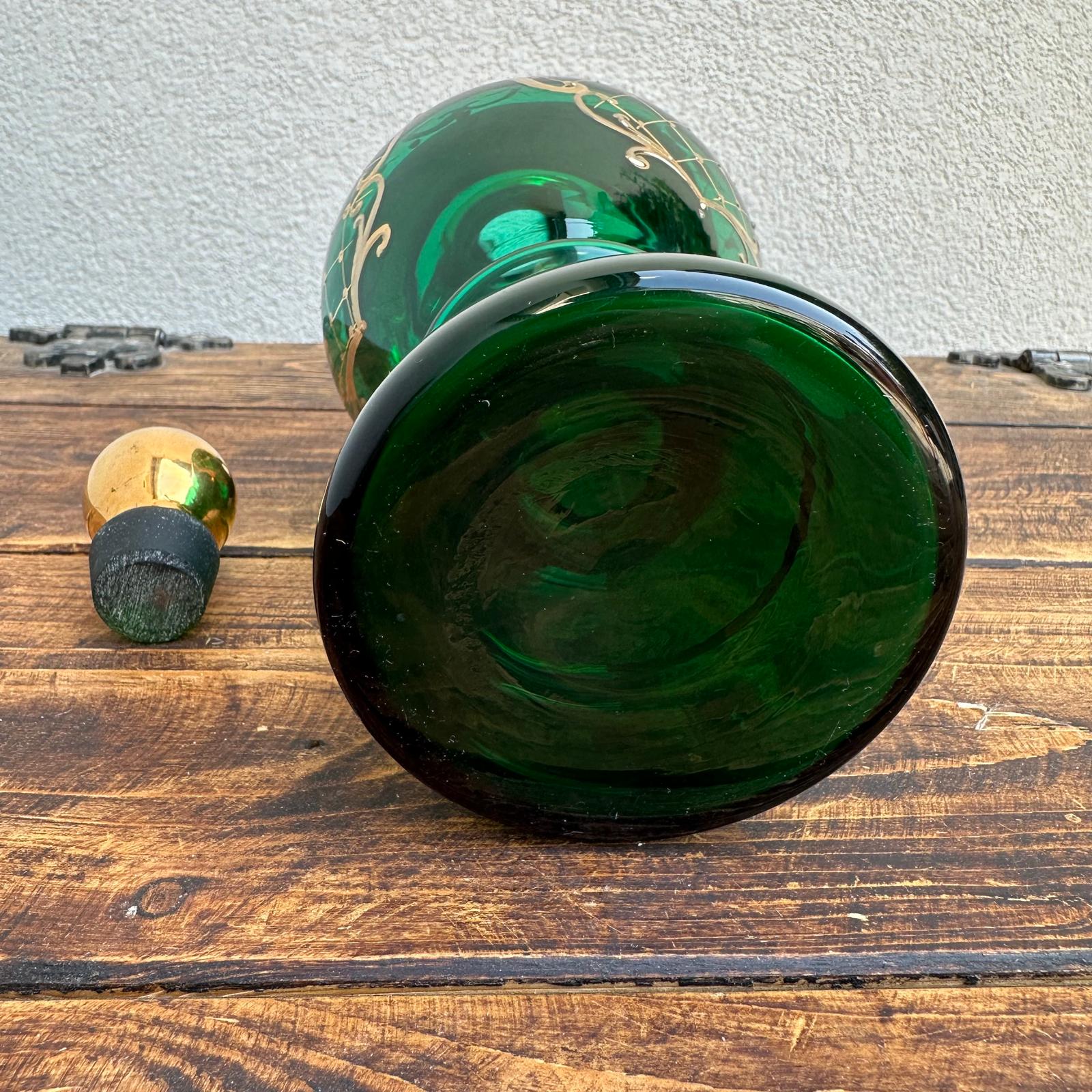 Green glass bottle with decorative top on a wooden surface