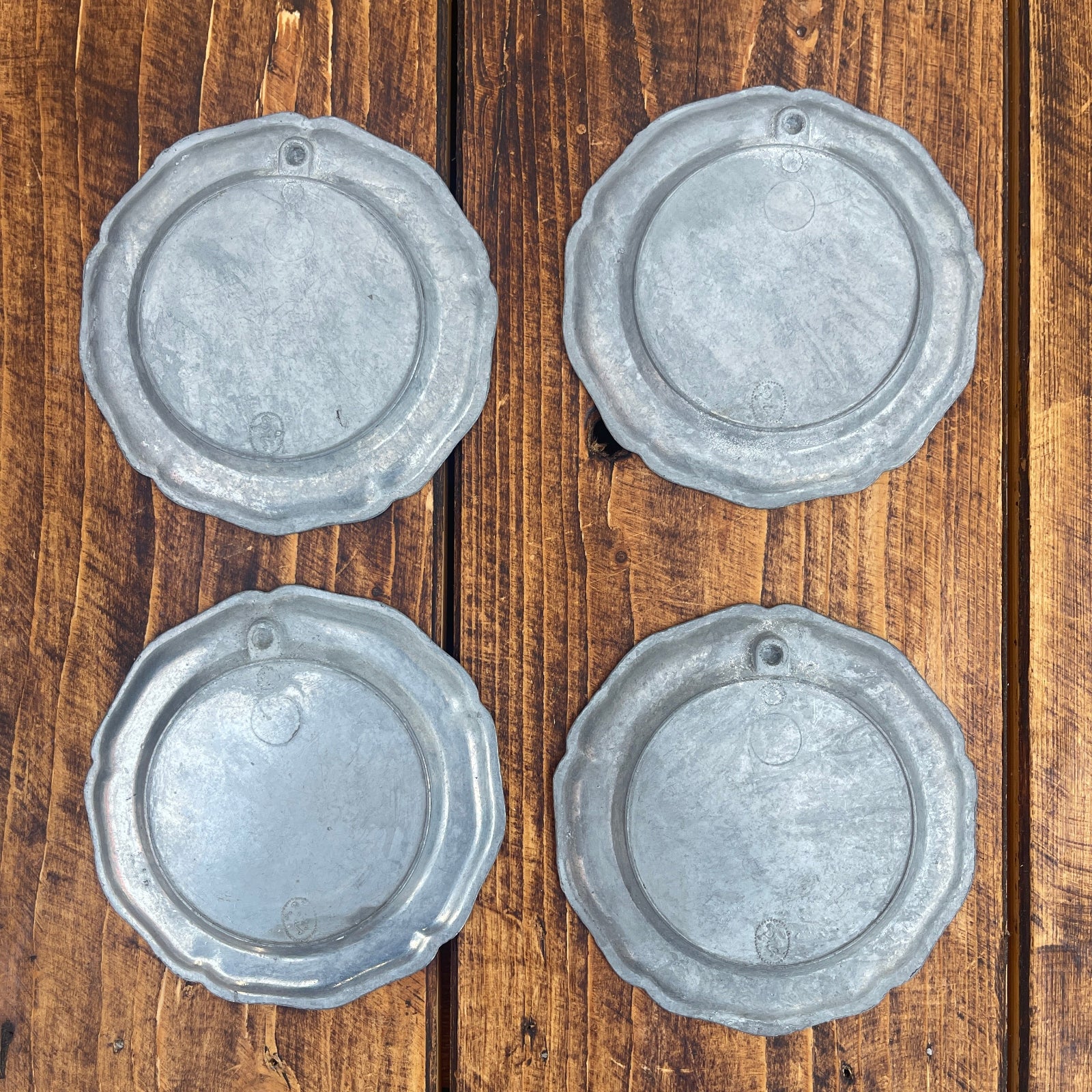 Four metallic circular objects on a wooden surface