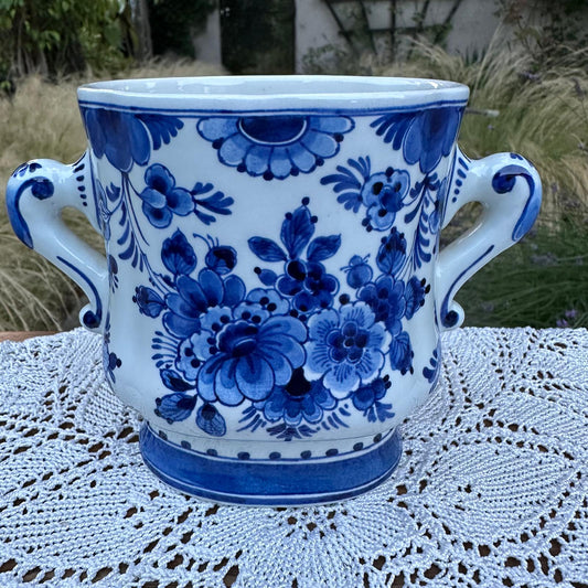 Ceramic mug with blue floral patterns on a lace tablecloth outdoors