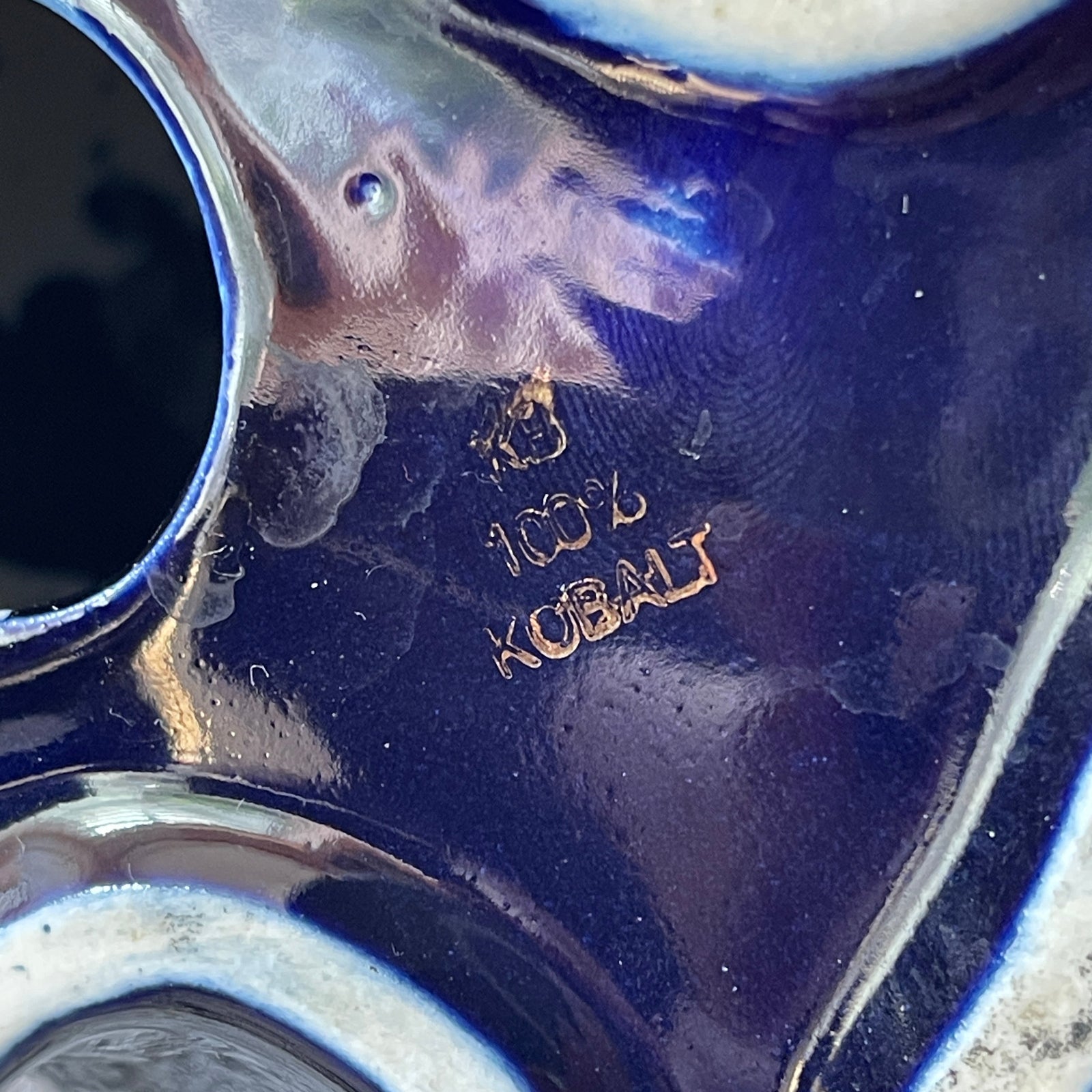 Close-up of a blue glass object with '100% Cobalt' inscription