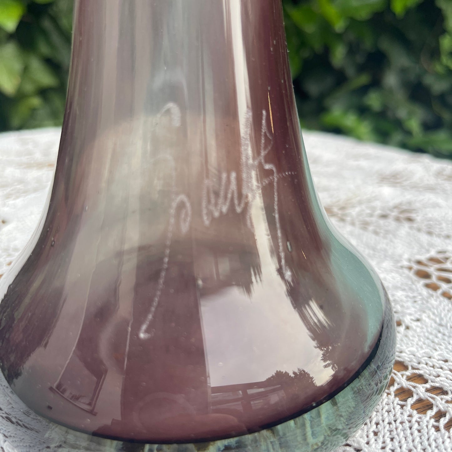Brown glass vase with engraved text on a textured surface